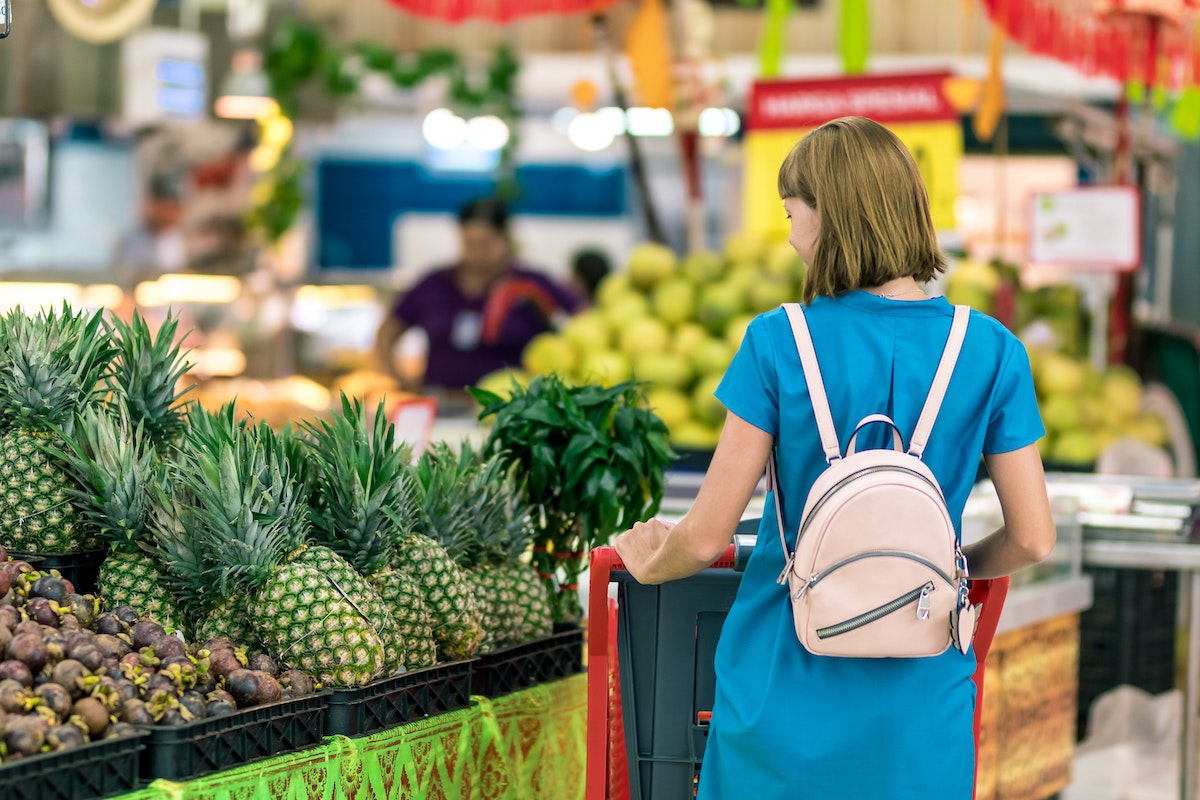 woman-standing-beside-pineapple-fruits-grocery-store.jpg