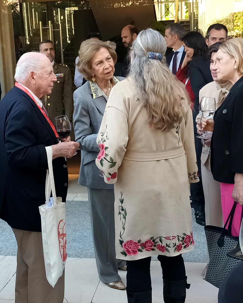 Reina Sophia and Betsy Boon in conversation in the centre of a group of onlookers