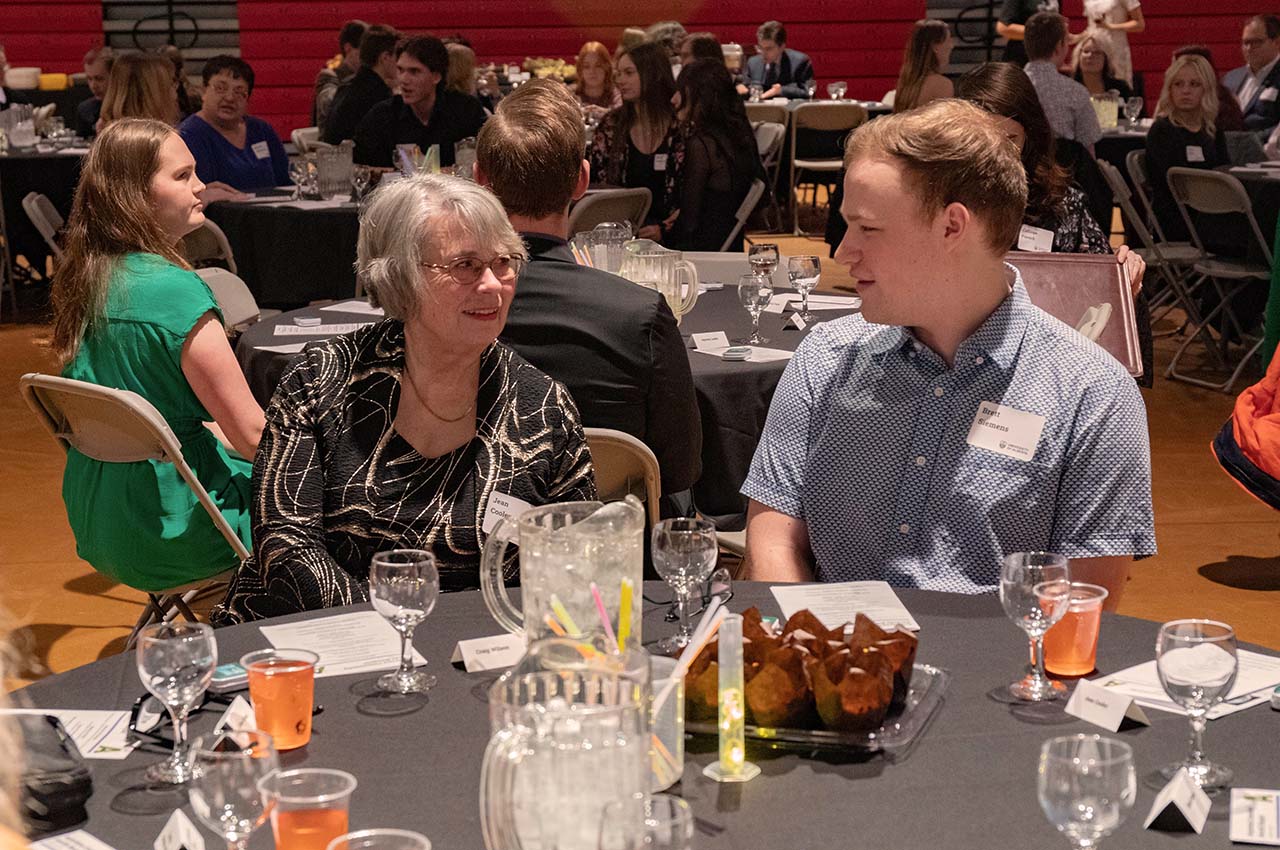 A student and donor speaking at a table.