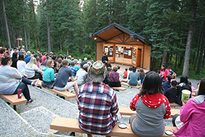 An amphitheater of people watching a presentation outdoors
