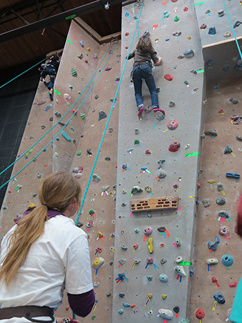 A photo of a person near the top of the climbing wall