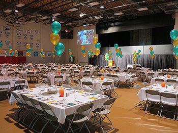 A photo of the gymnasium set up with tables for an awards event