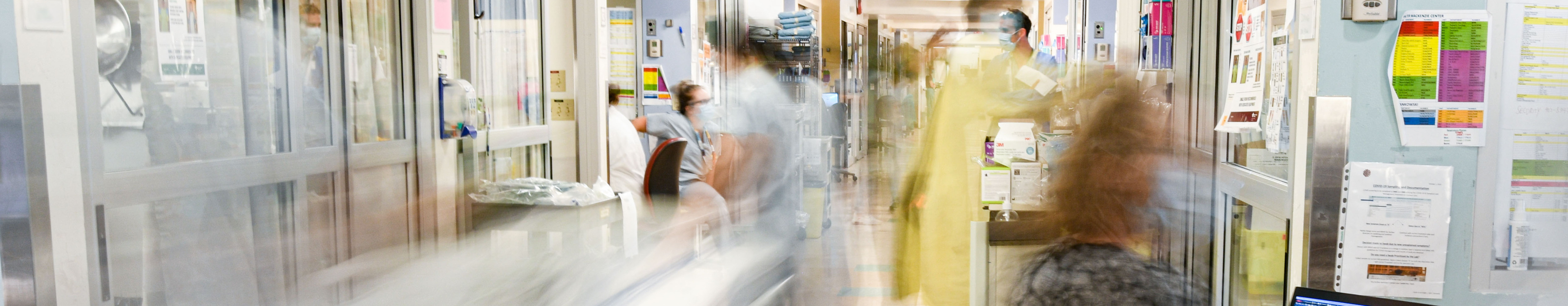 Healthcare workers bustling in a high-paced, critical care hospital setting.