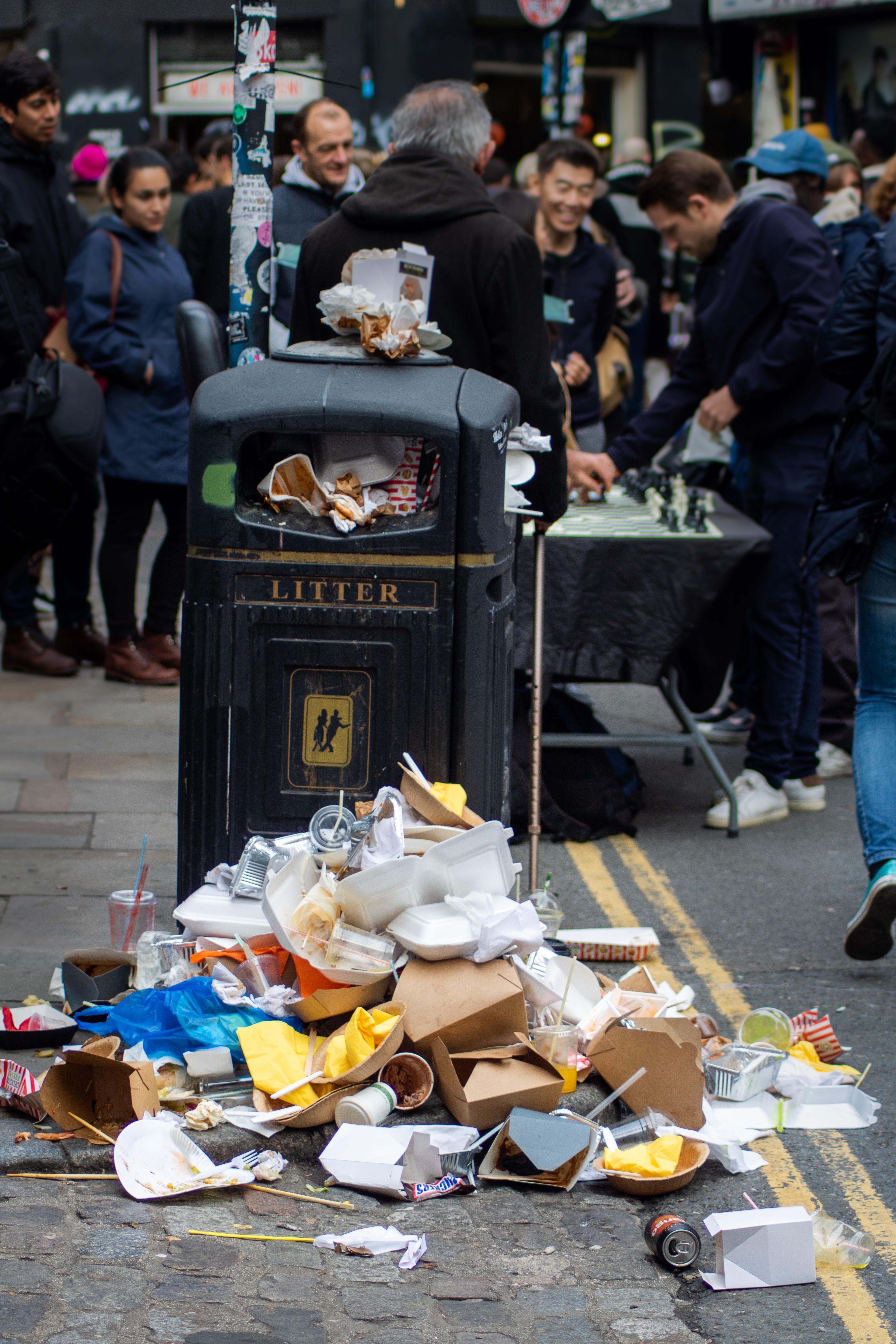 Trash overflowing a bin.