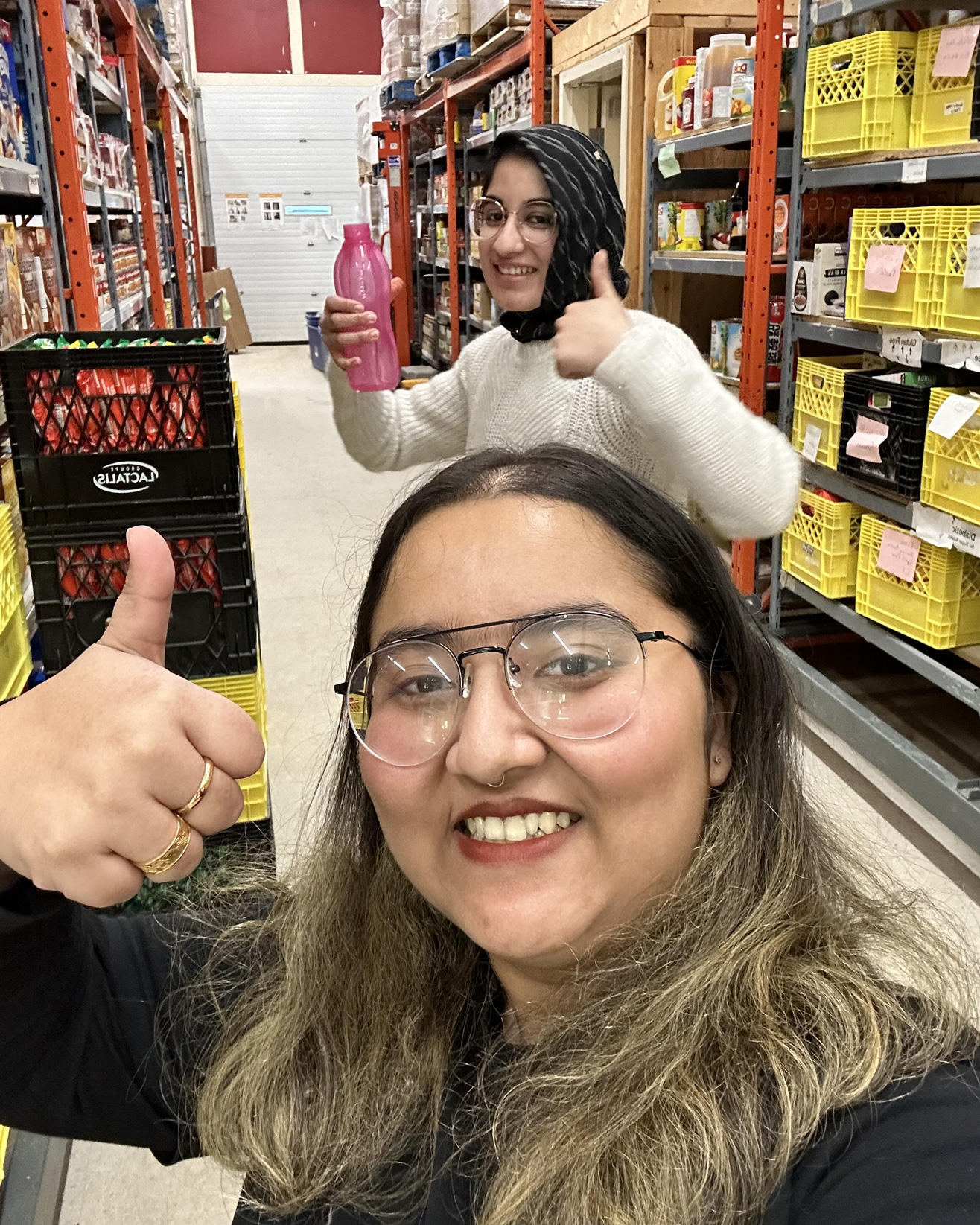 Ima and Munira pose inside the isle of the food bank