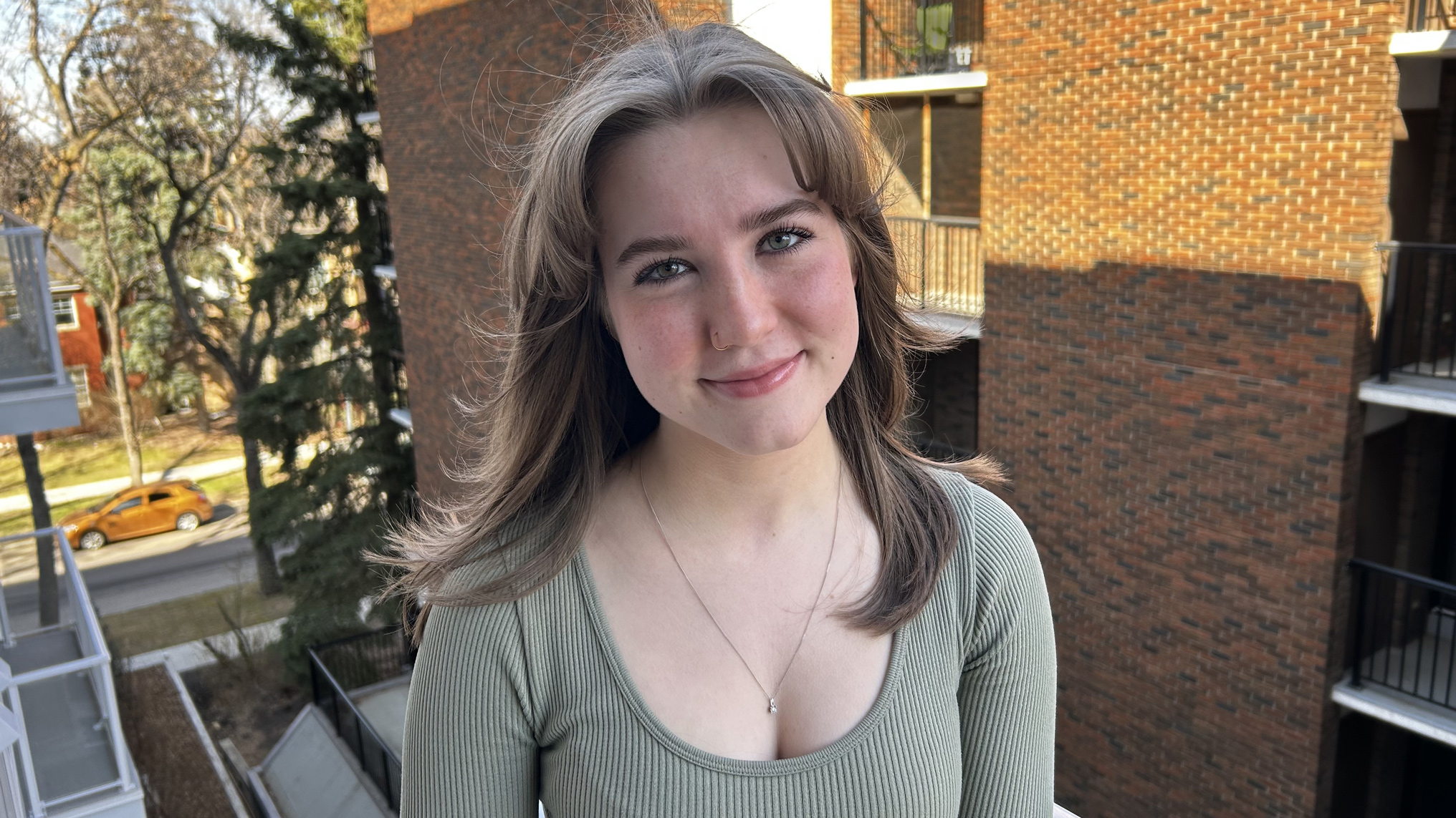 Photo of Sierra smiling out on an apartment balcony