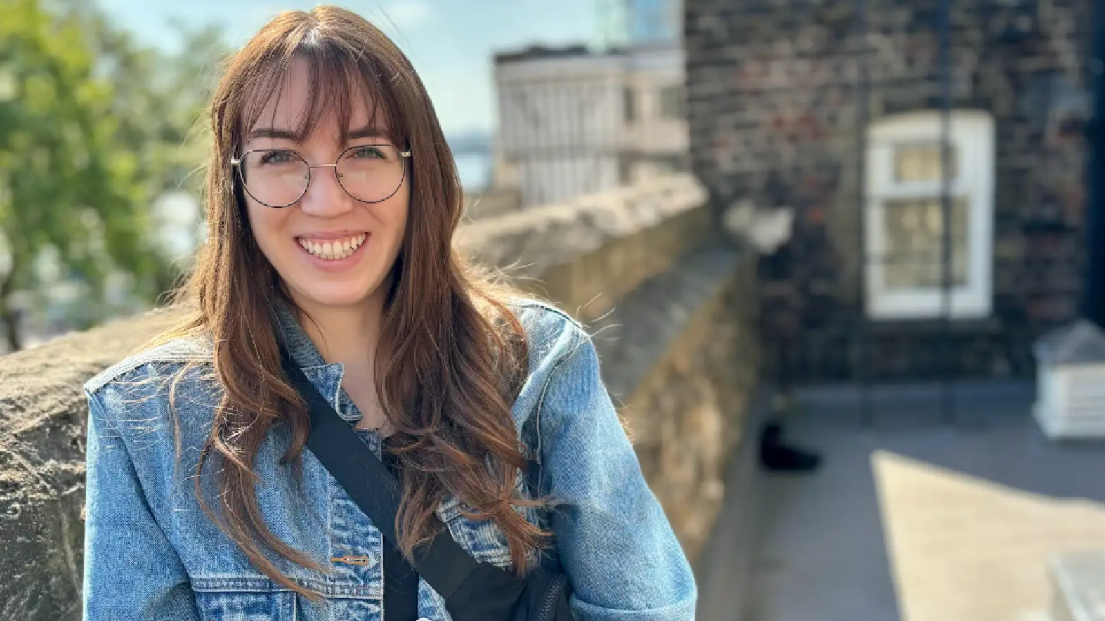 Student standing on a building patio overlooking a park.