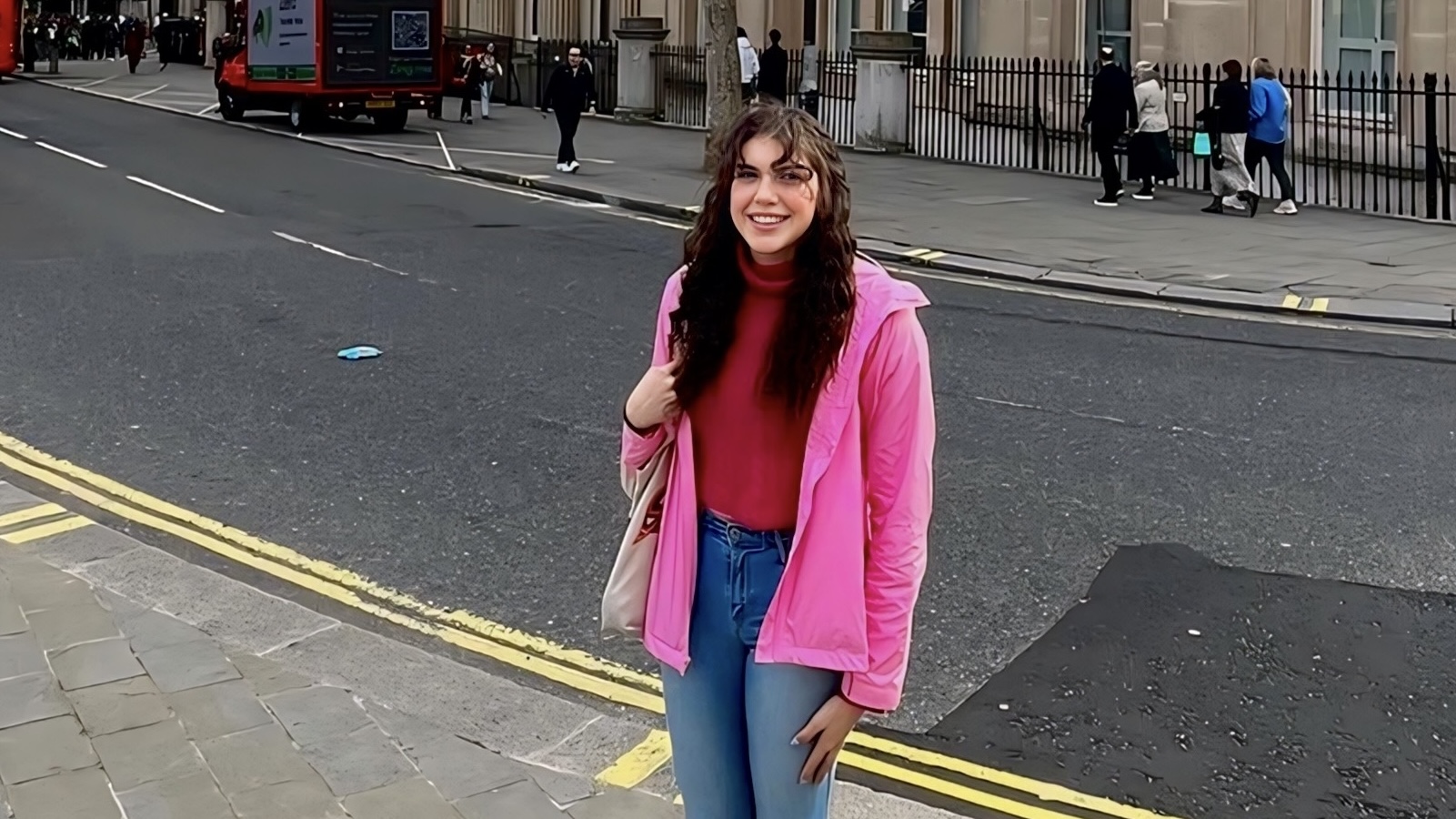 The student standing in front of a busy street.