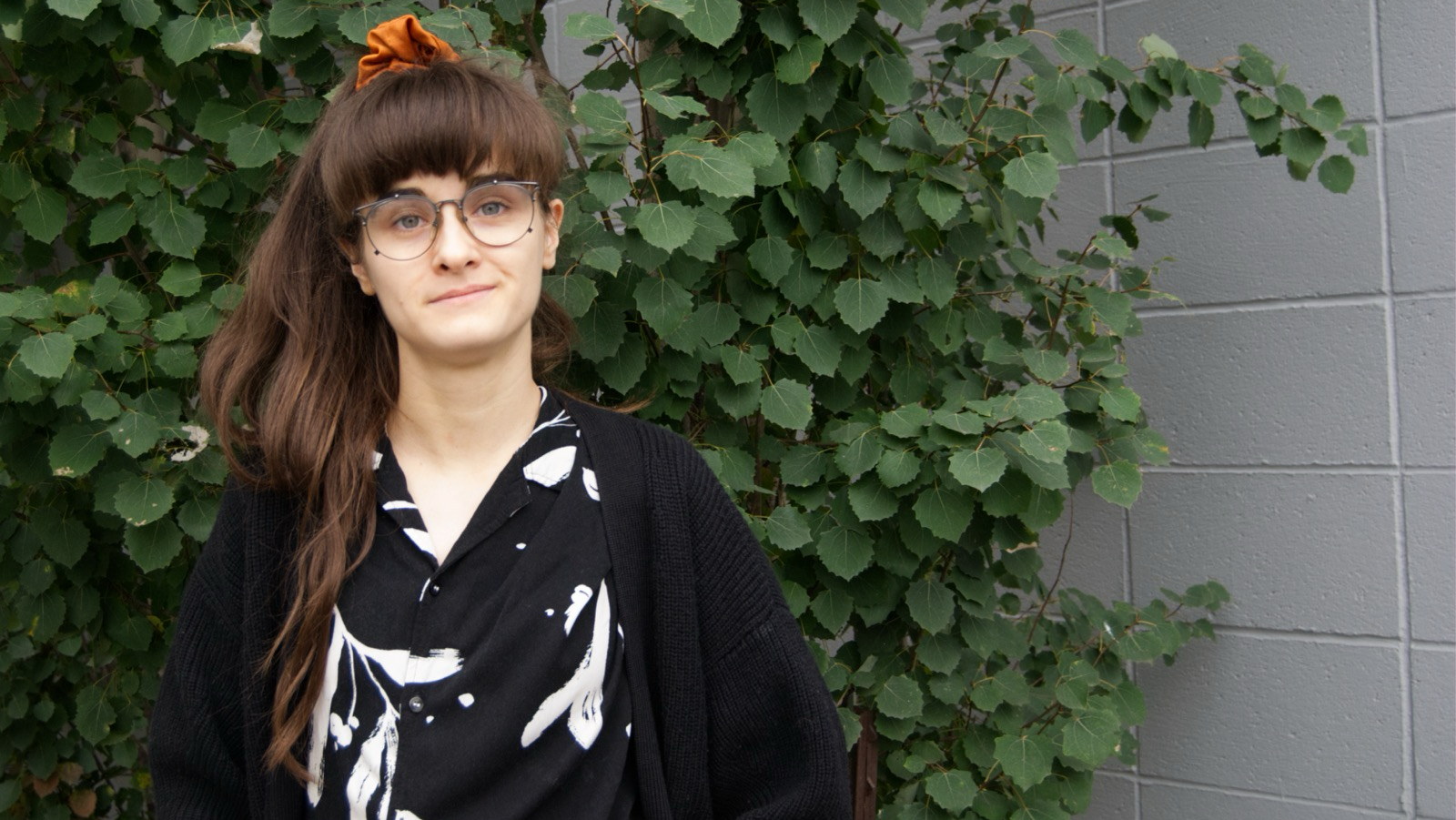 student portrait in front of greenery.