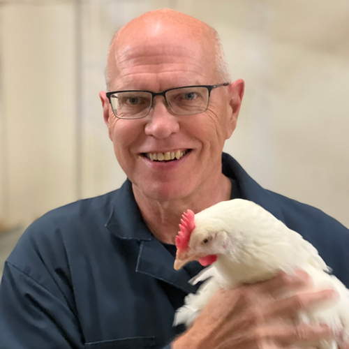 Frank poses holding a chicken