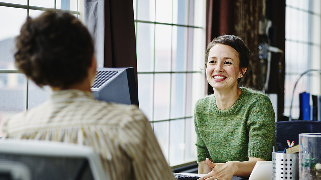 Getty Images: smiling business owners at workstation in office.