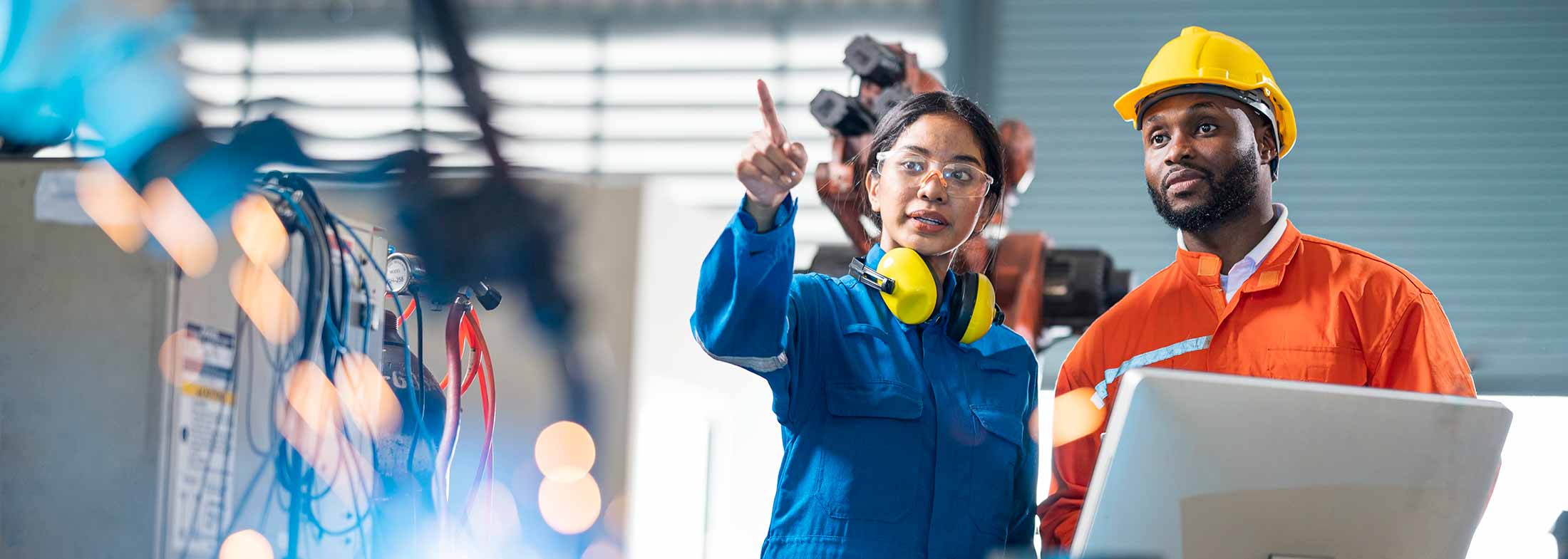 Two engineers with safety equipment work on a project