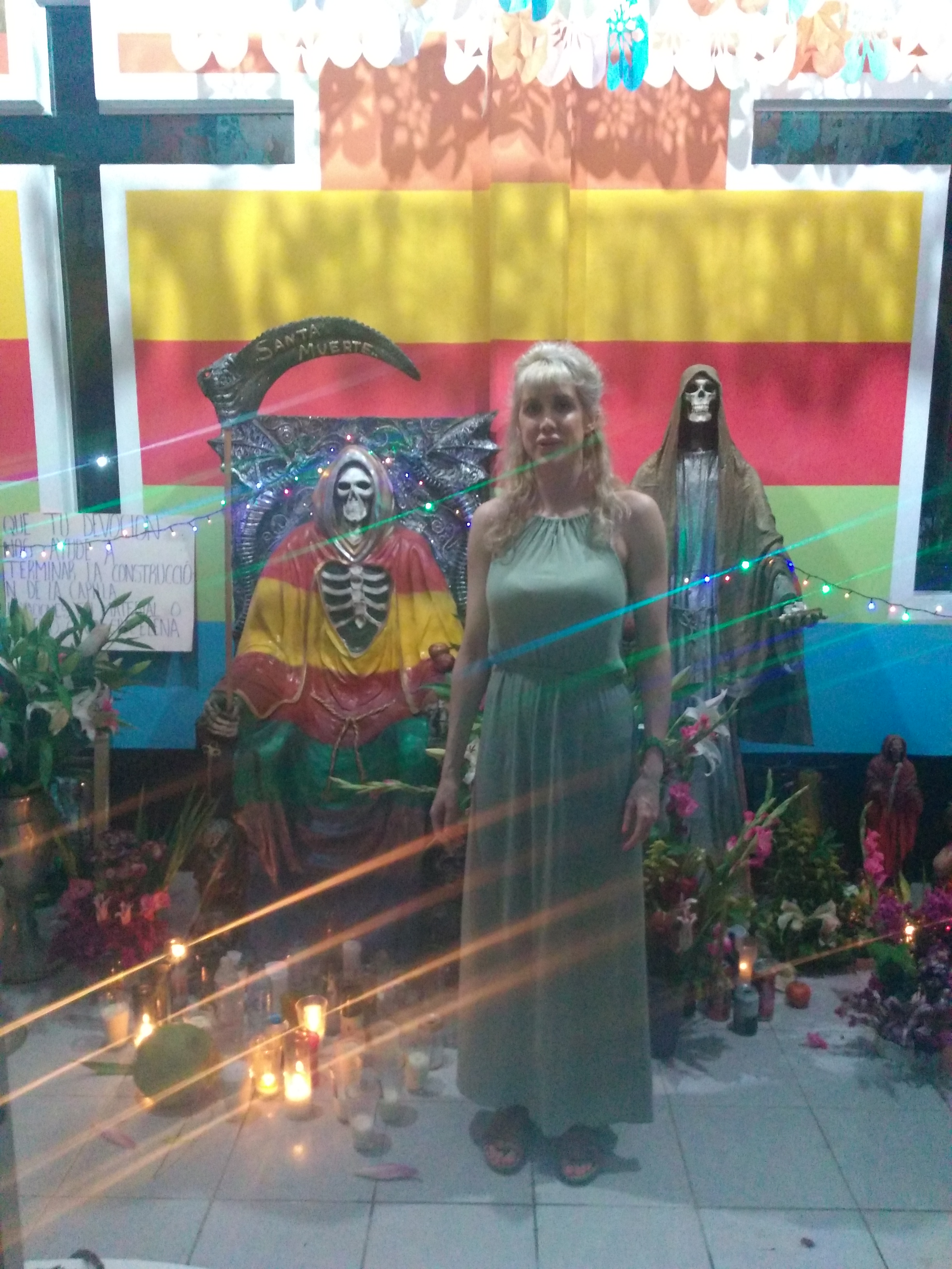 Dr. Kate Kingsbury standing in front of a Santa Muerte shrine