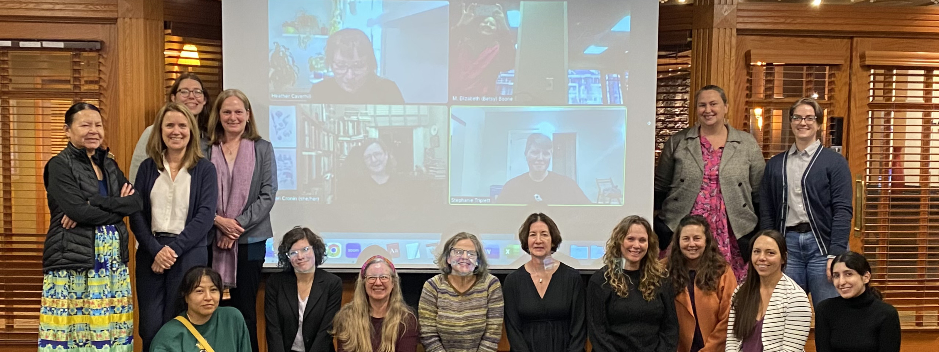 forum participants pose in front of the projection screen