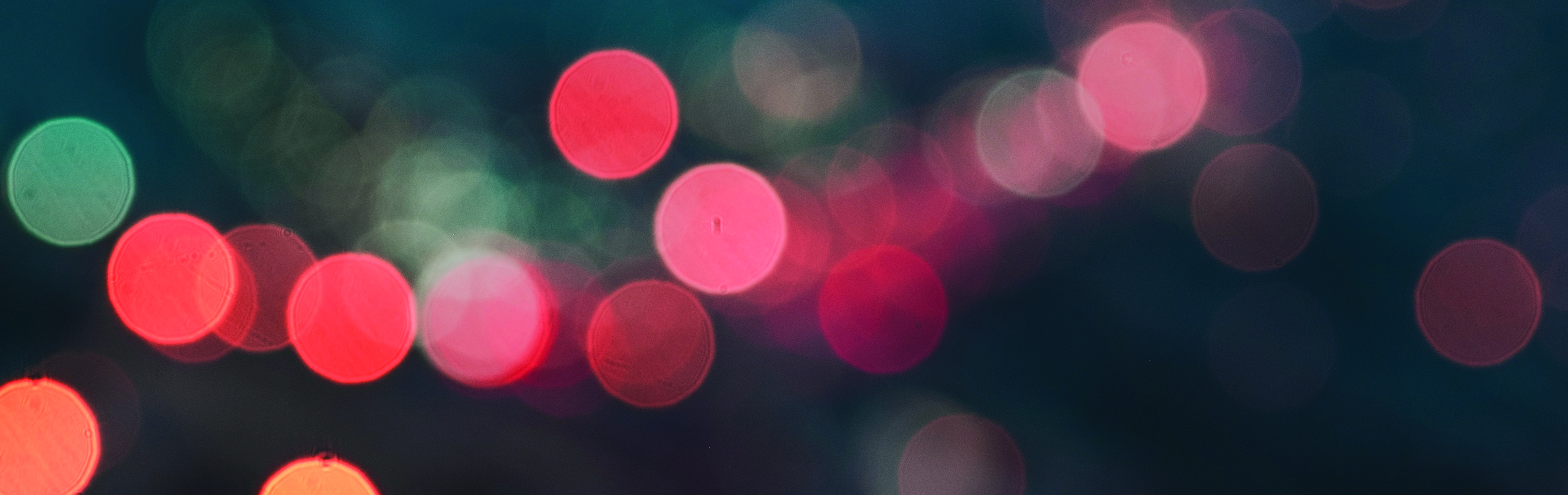 blurred bokeh light in aqua, red and orange on a dark background