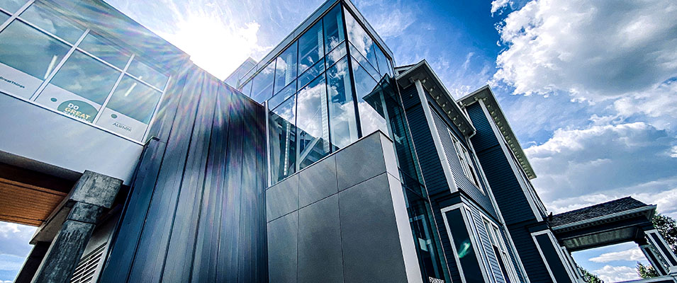 A perspectived photo of the corner of Founders' Hall looking up towards a blue sky