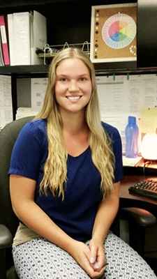 A photo of Megan Patenaude facing the camera while sitting in an office chair.