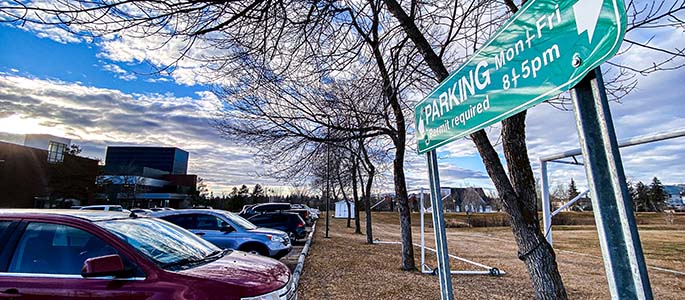 A photo of cars parked at Augustana, with a parking sign included