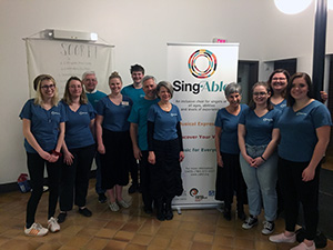 Research assistants and volunteers posing around a SingAble sign