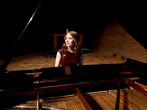 A photo of Candice Huculiak sitting at a piano