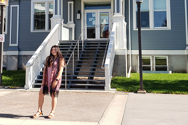 A photo of Aurora Tupechka in front of Founders' Hall.