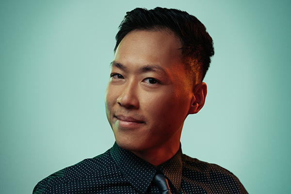 A photo of Tony Nguyen wearing a suit in front of a blue background.