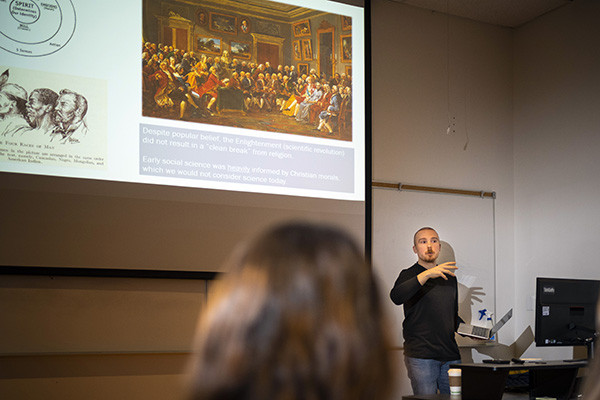 A man standing in front of a classroom and teaching.