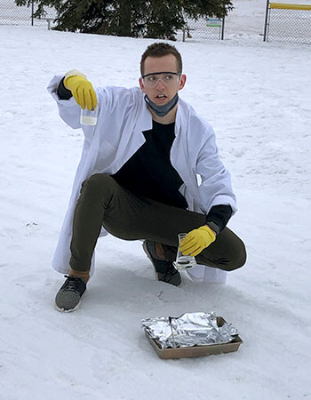 A photo of Cole Feth doing a science experiment outdoors