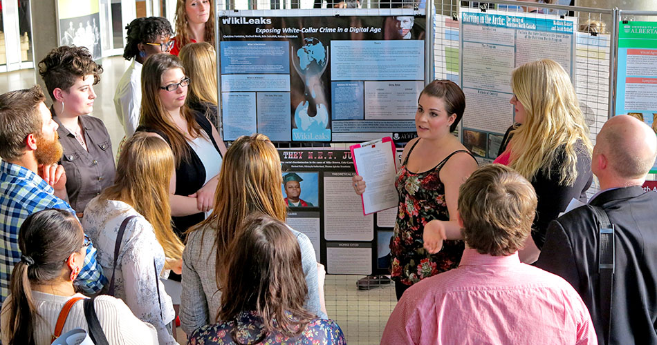 A photo of a group of students doing a presentation on WikiLeaks to a crowd.