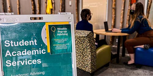 A photo of a student sitting with an Academic Advisor at a pop-up session