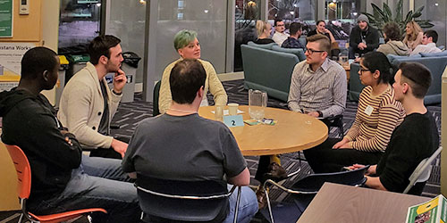 A photo of three students sitting and smiling in a residence room