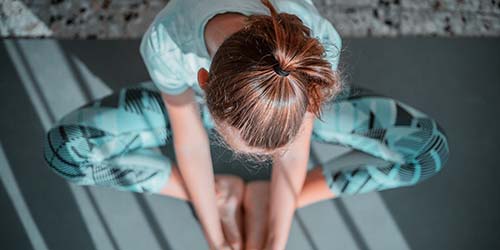 A photo of a young person stretching or meditating