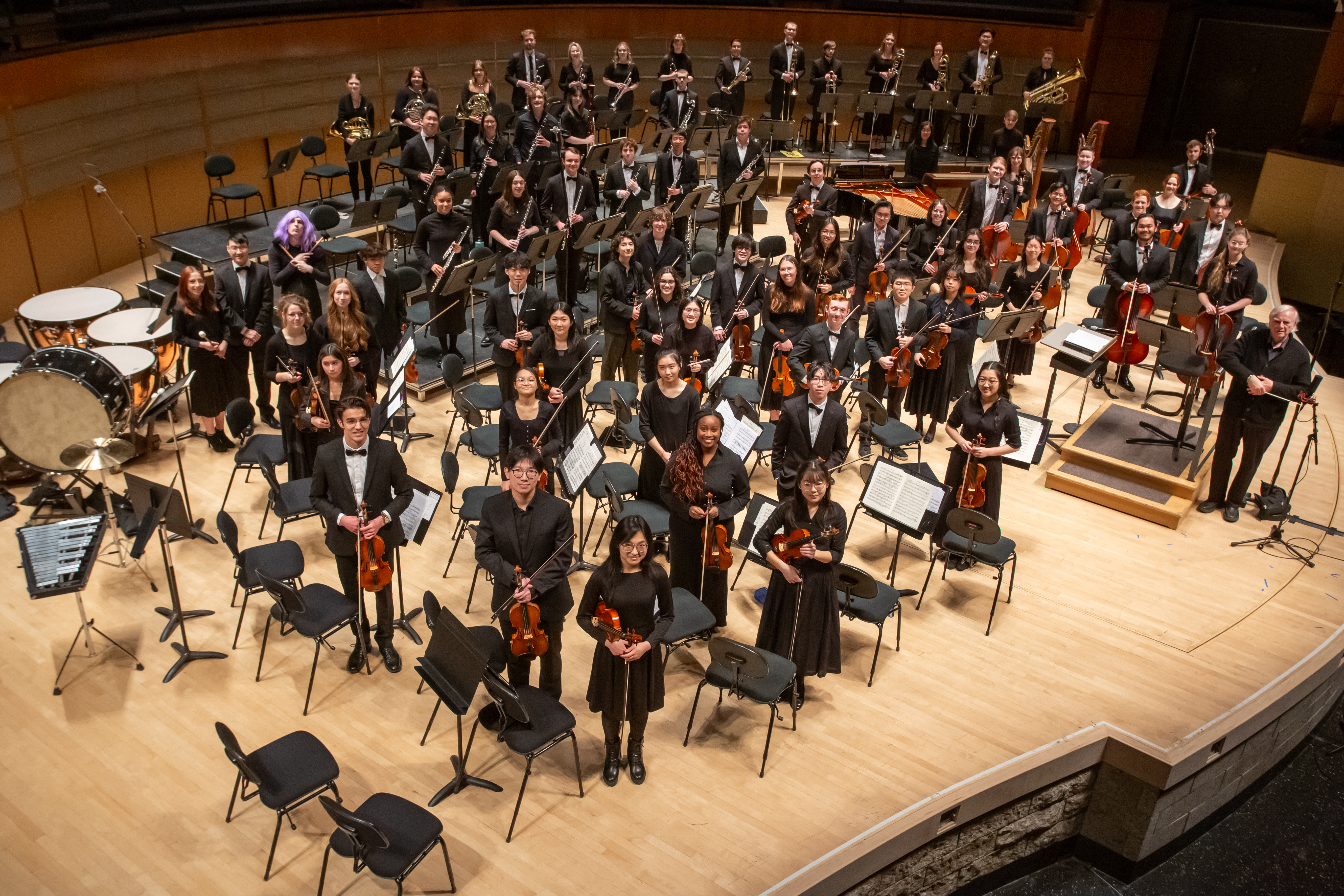 Senior Edmonton Youth Orchestra members smiling with instruments