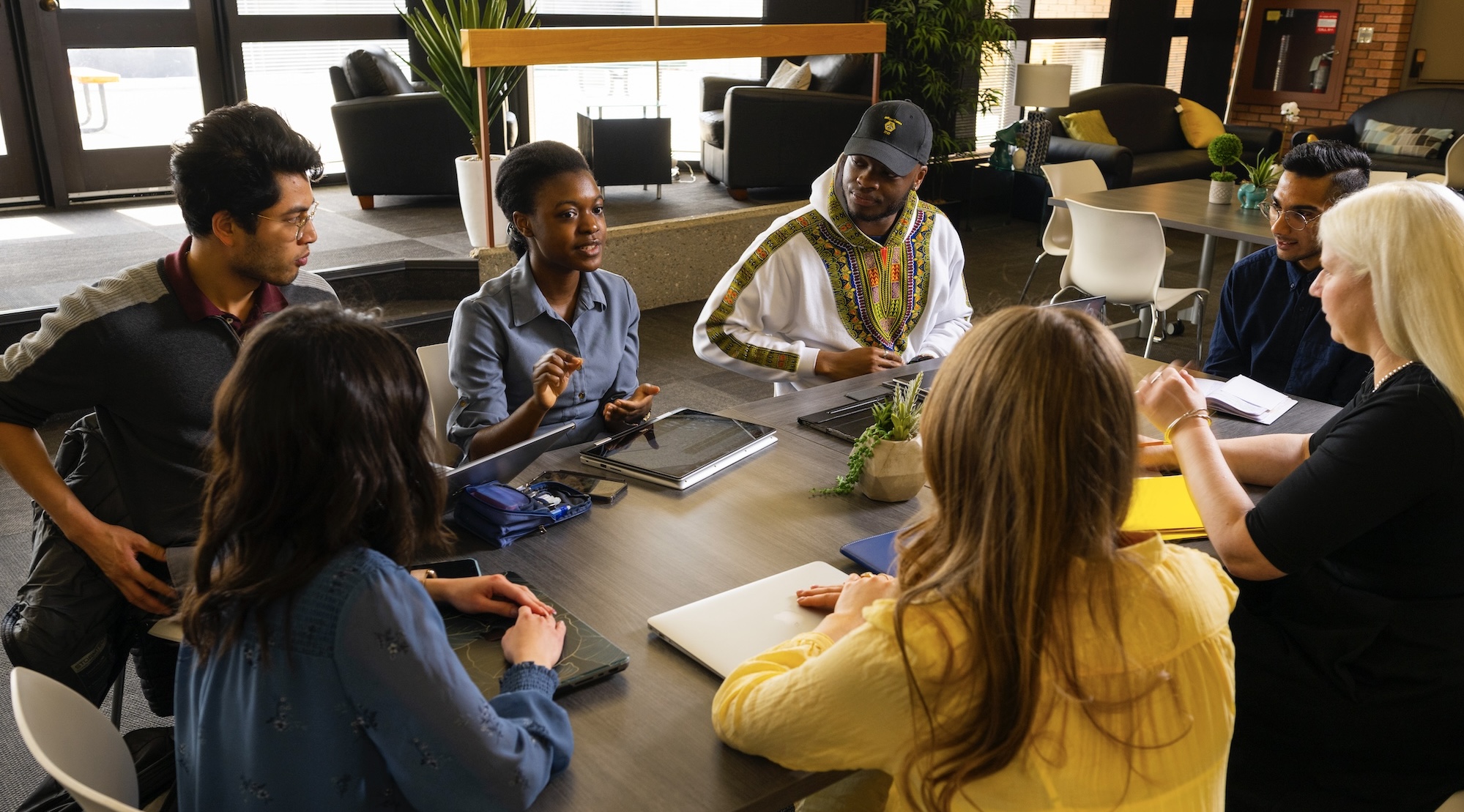 A group of people gathered around the table to discuss