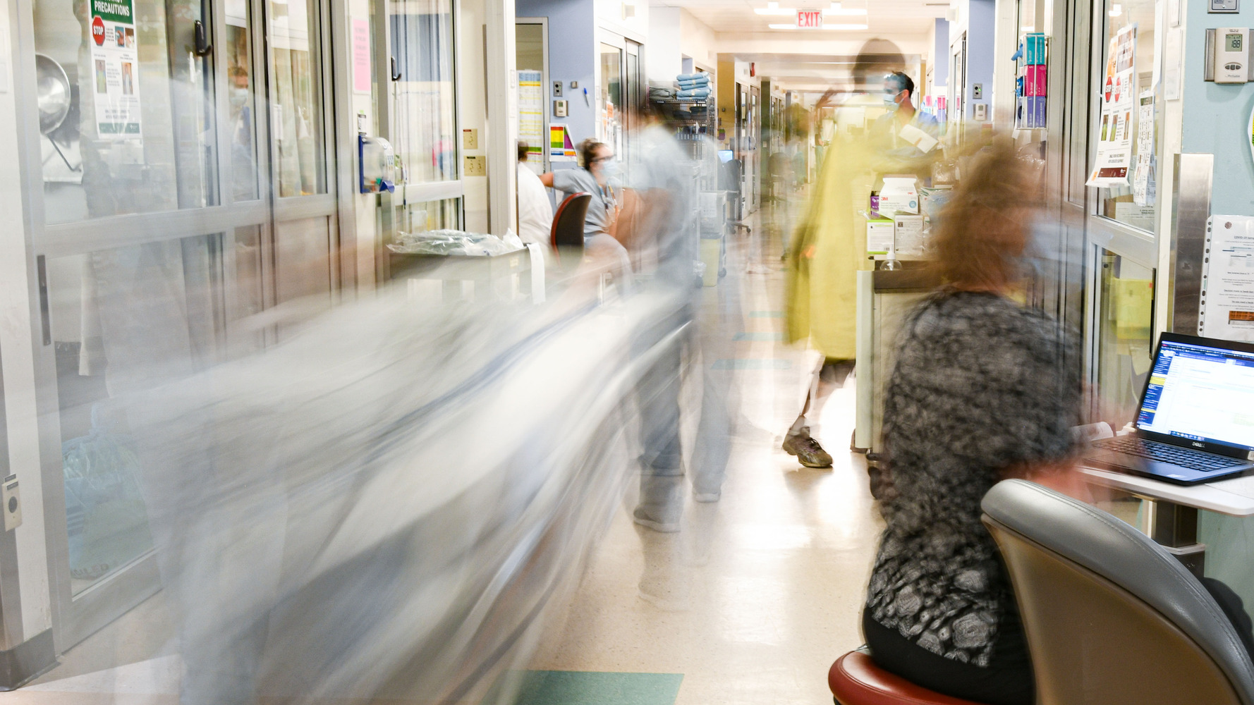 Healthcare workers bustling in a high-paced, critical care hospital setting.