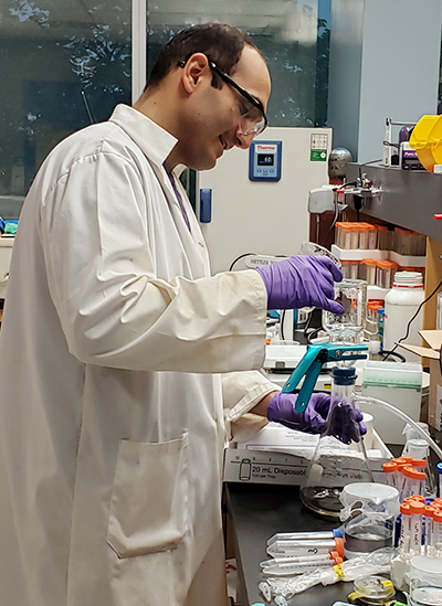 Dr. Salman Safarimohsenabad pouring liquid into a filtration setup