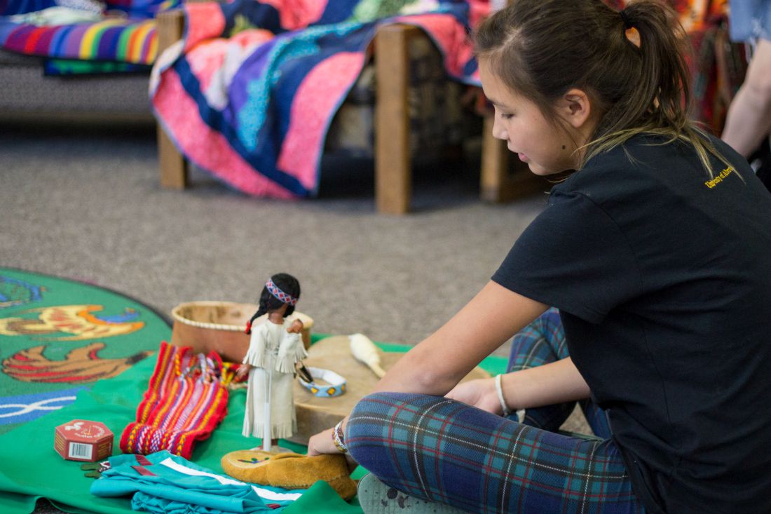 Child playing with indigenous items