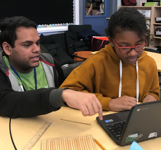 Mohamed Bilal with student at a laptop