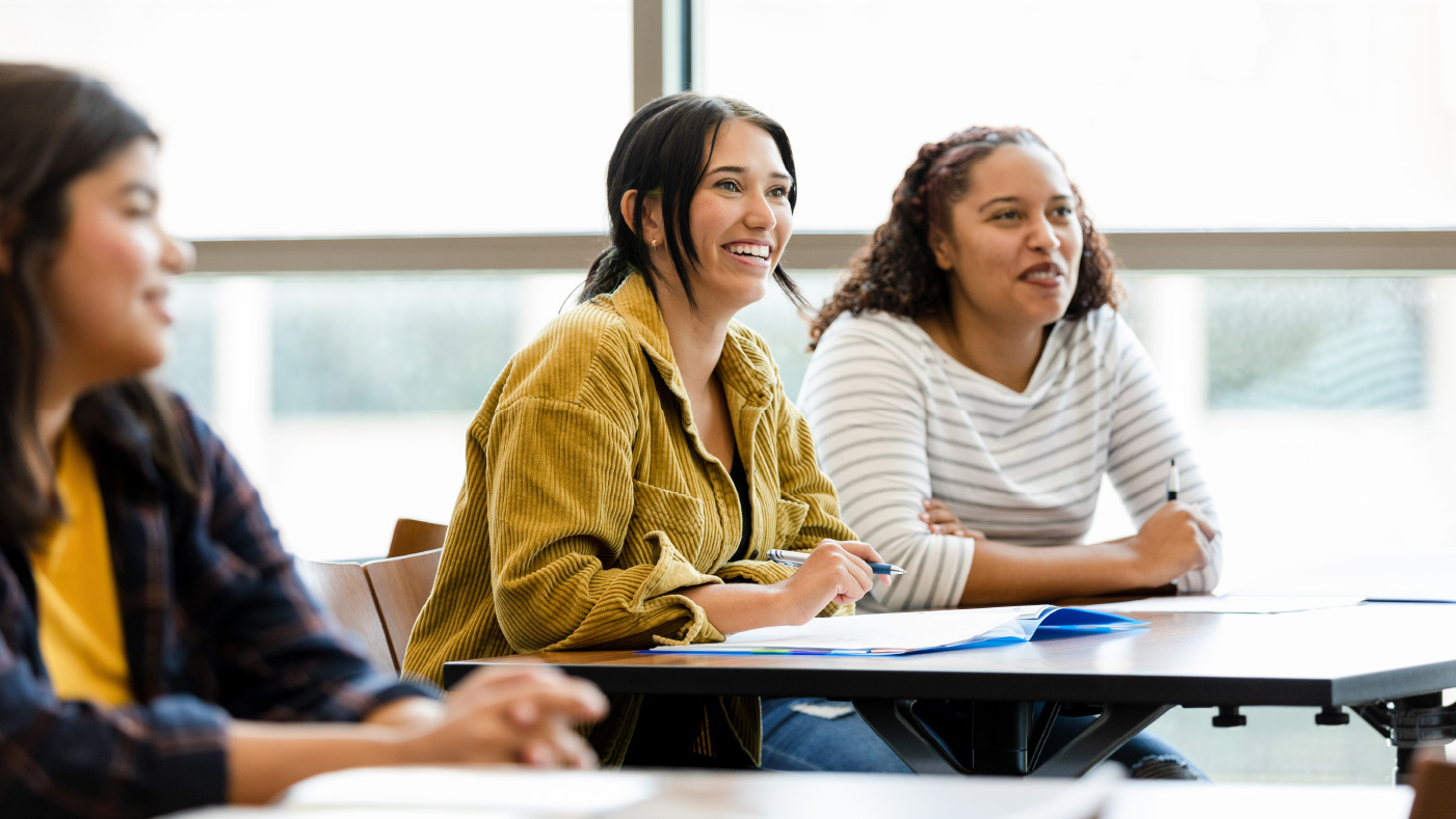 three people sitting at desks