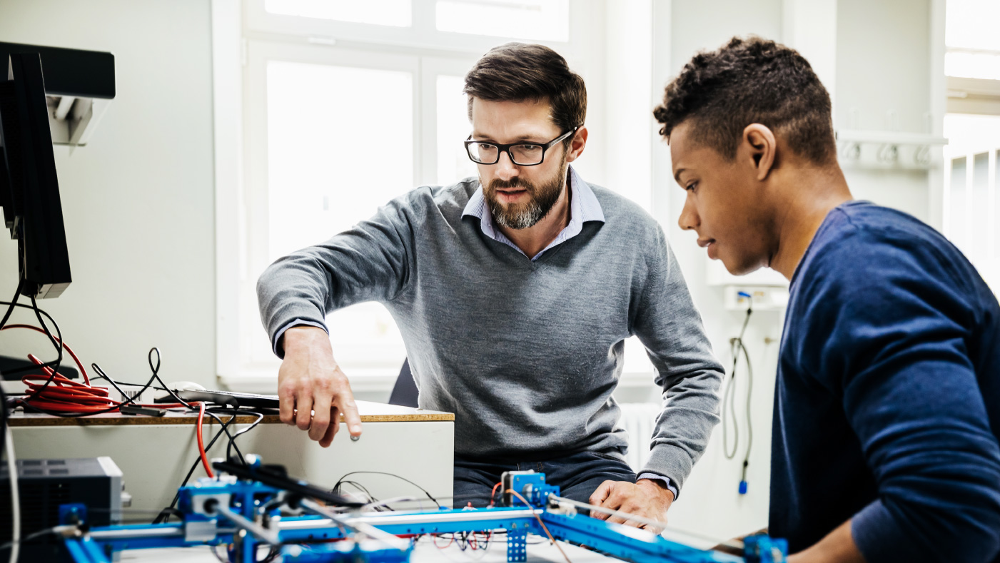 Two people working with electronics