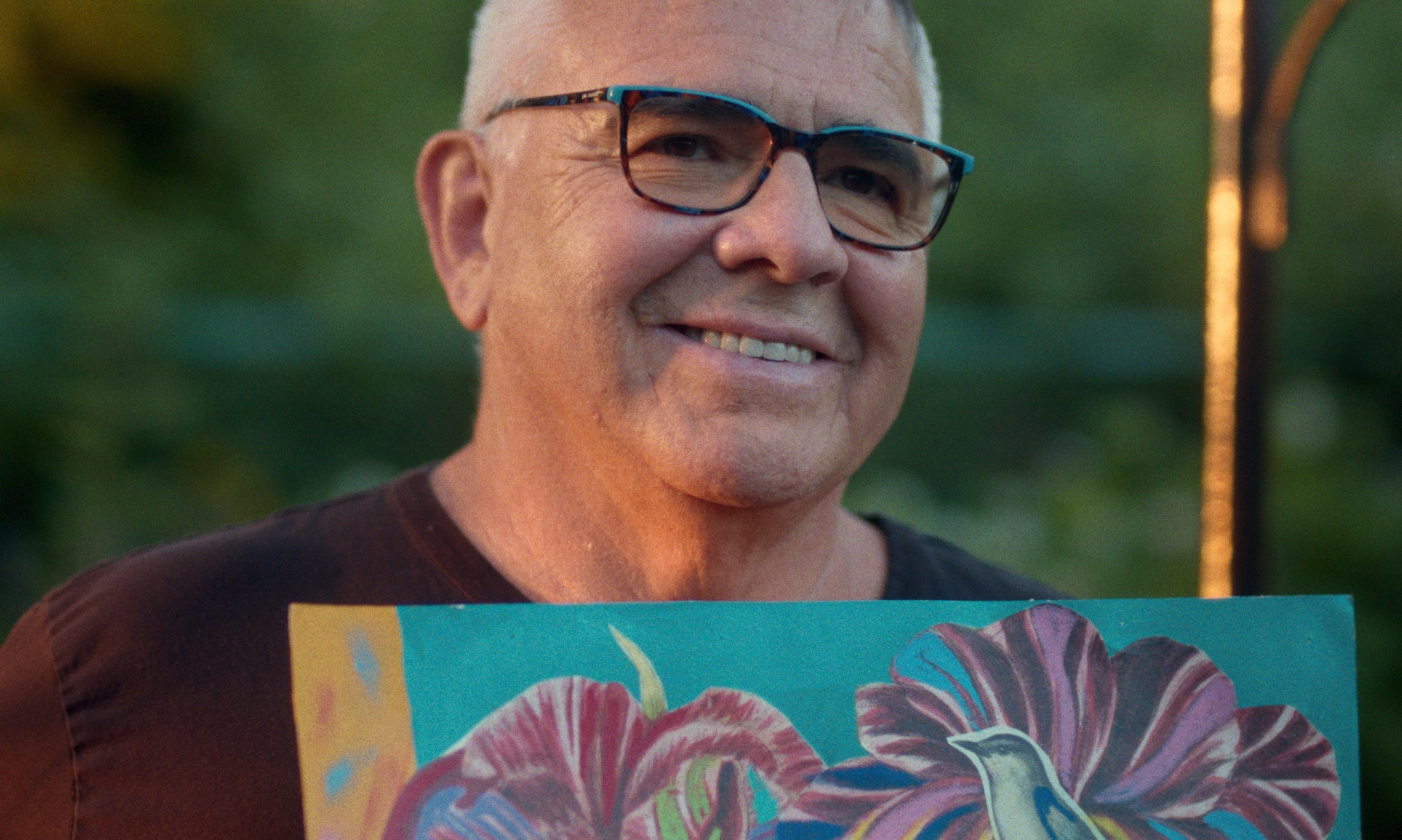 Connor McNally standing in front of a colourful painting