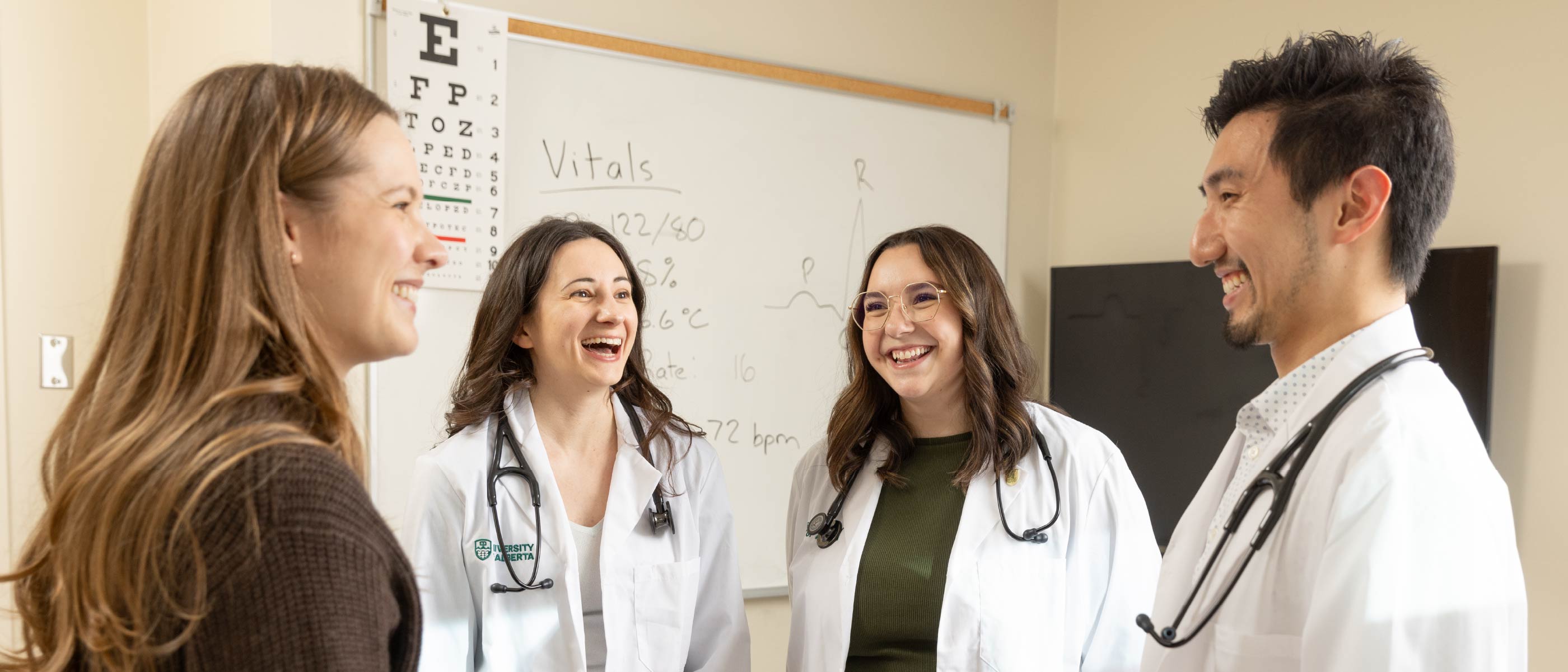 Group of students in lab coats talking on campus