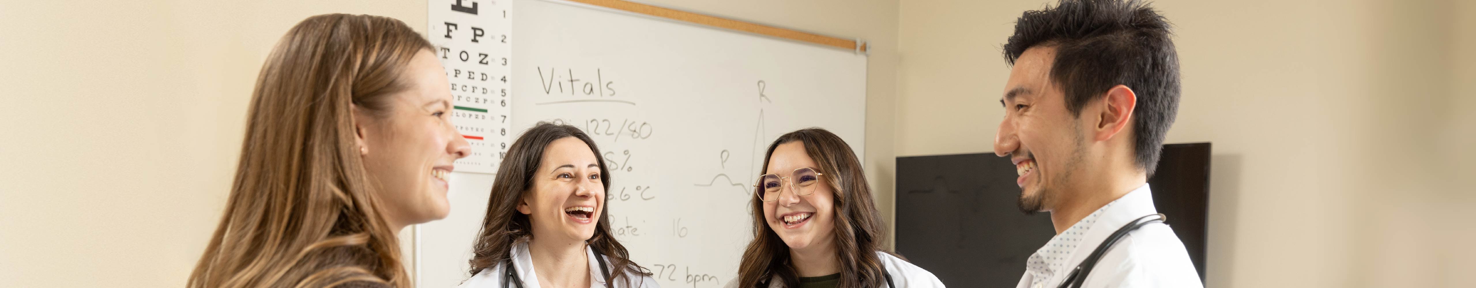 Group of students in lab coats talking on campus