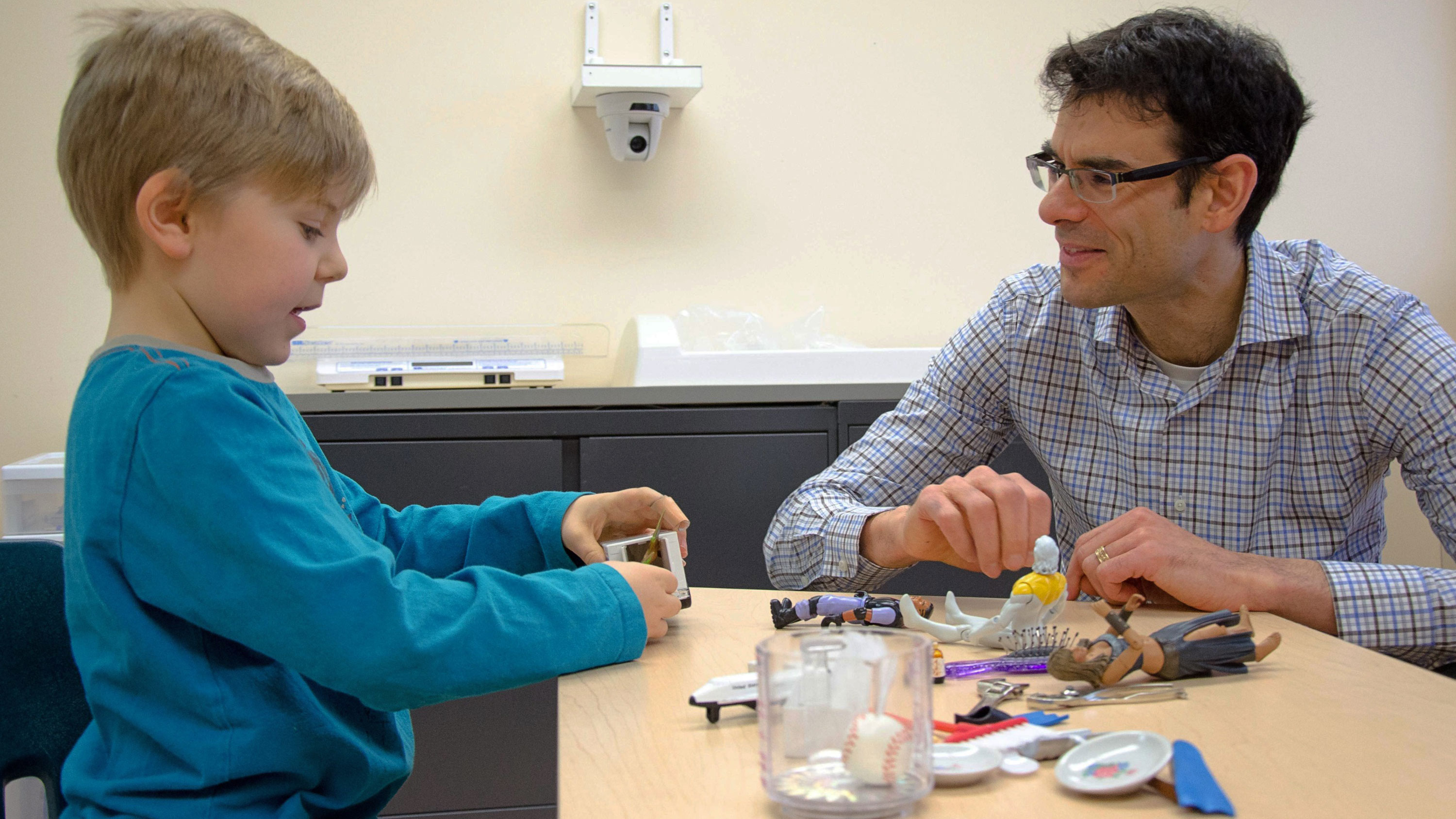 Pediatrics professor and autism researcher Lonnie Zwaigenbaum interacts with a young child as the child plays with toys. (Photo: Alberta Health Services)