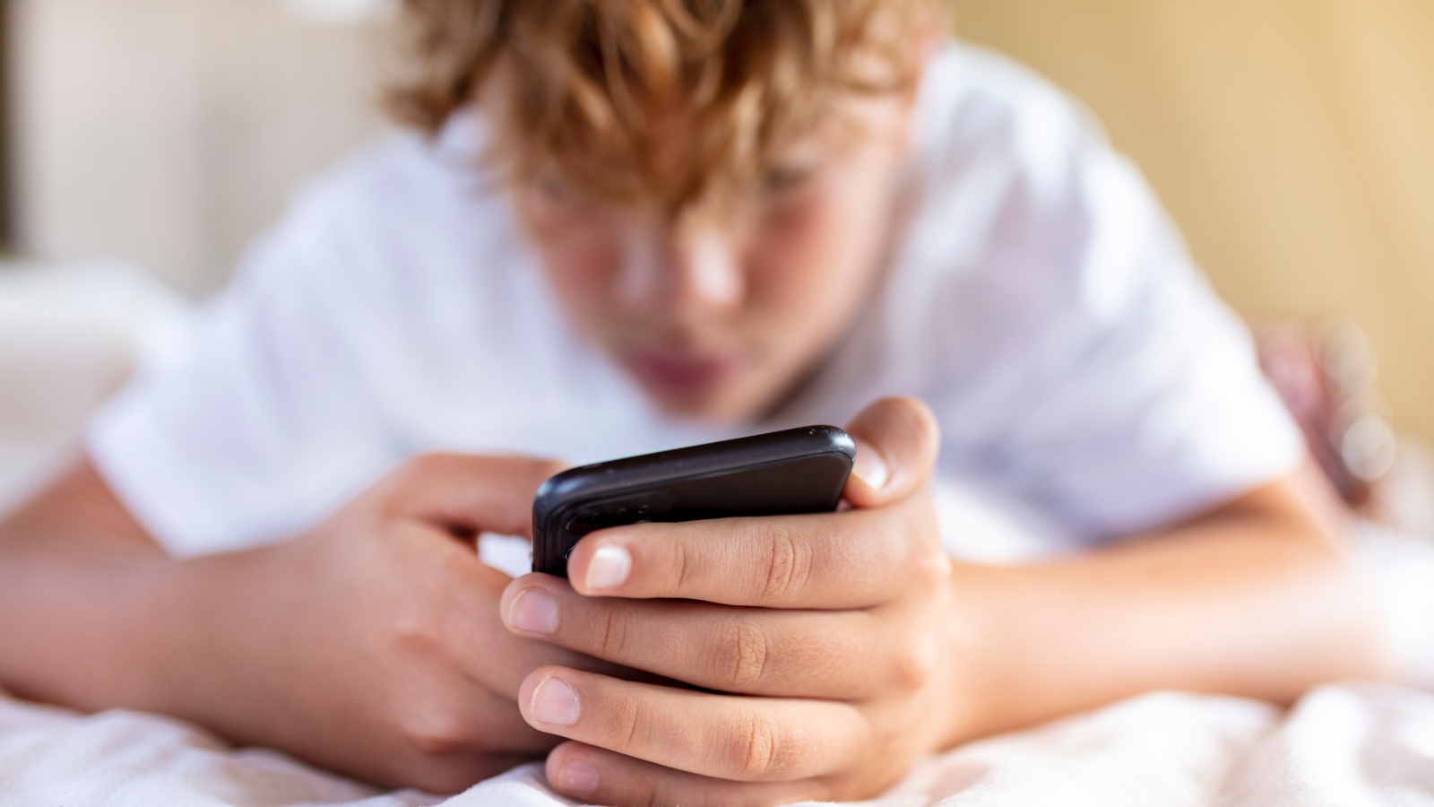 Teen looks at smartphone. (Photo: Getty Images)