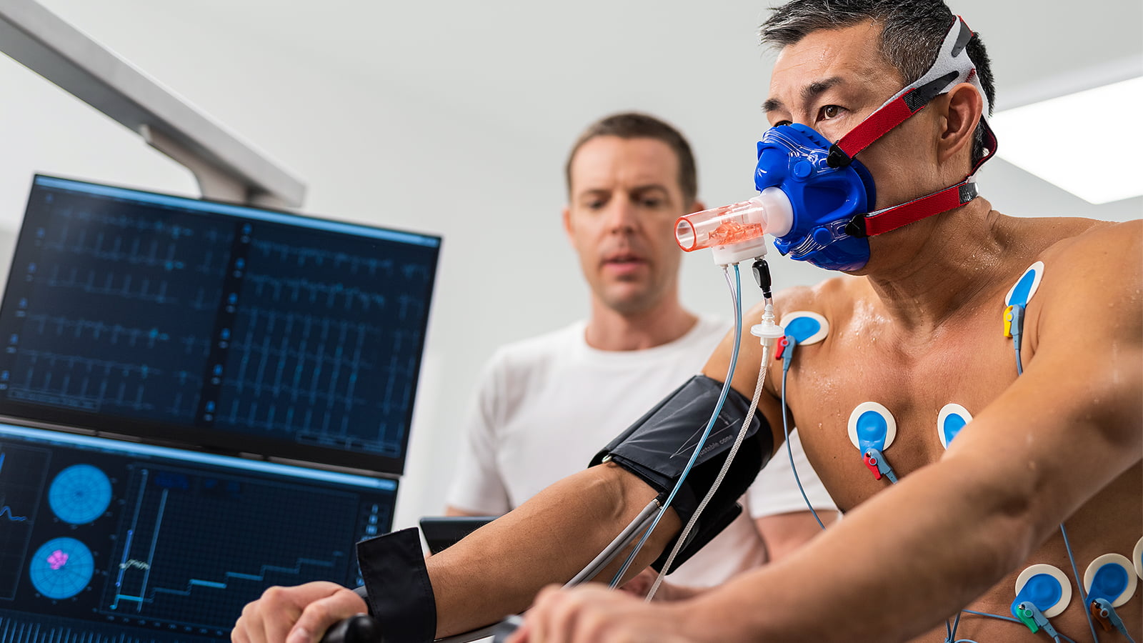 A man rides an exercise bike in a lab while being monitored with sensors and a mask to measure oxygen uptake. (Photo: Getty Images)