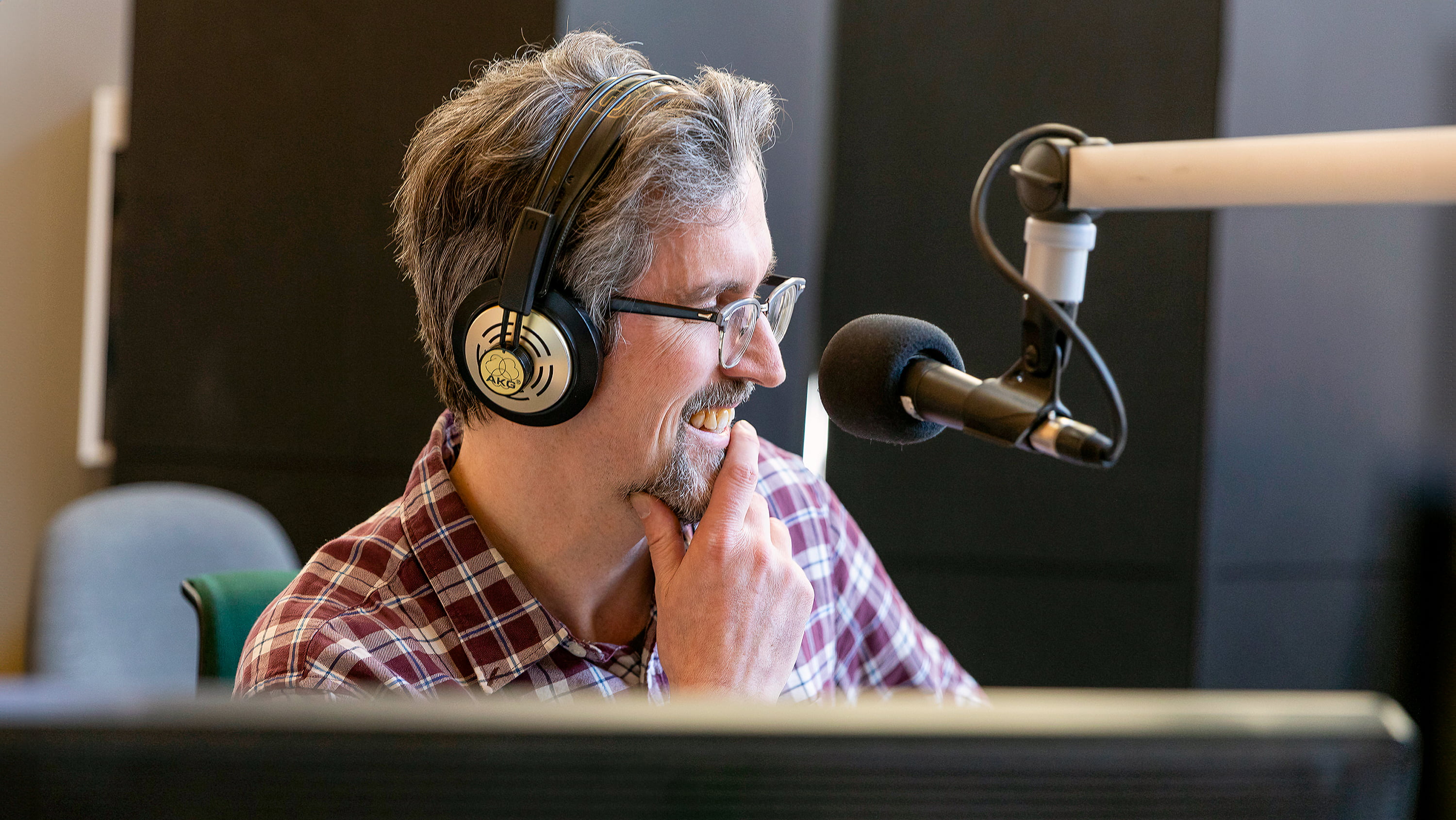 Grant Stovel sits with a mic in front of him.