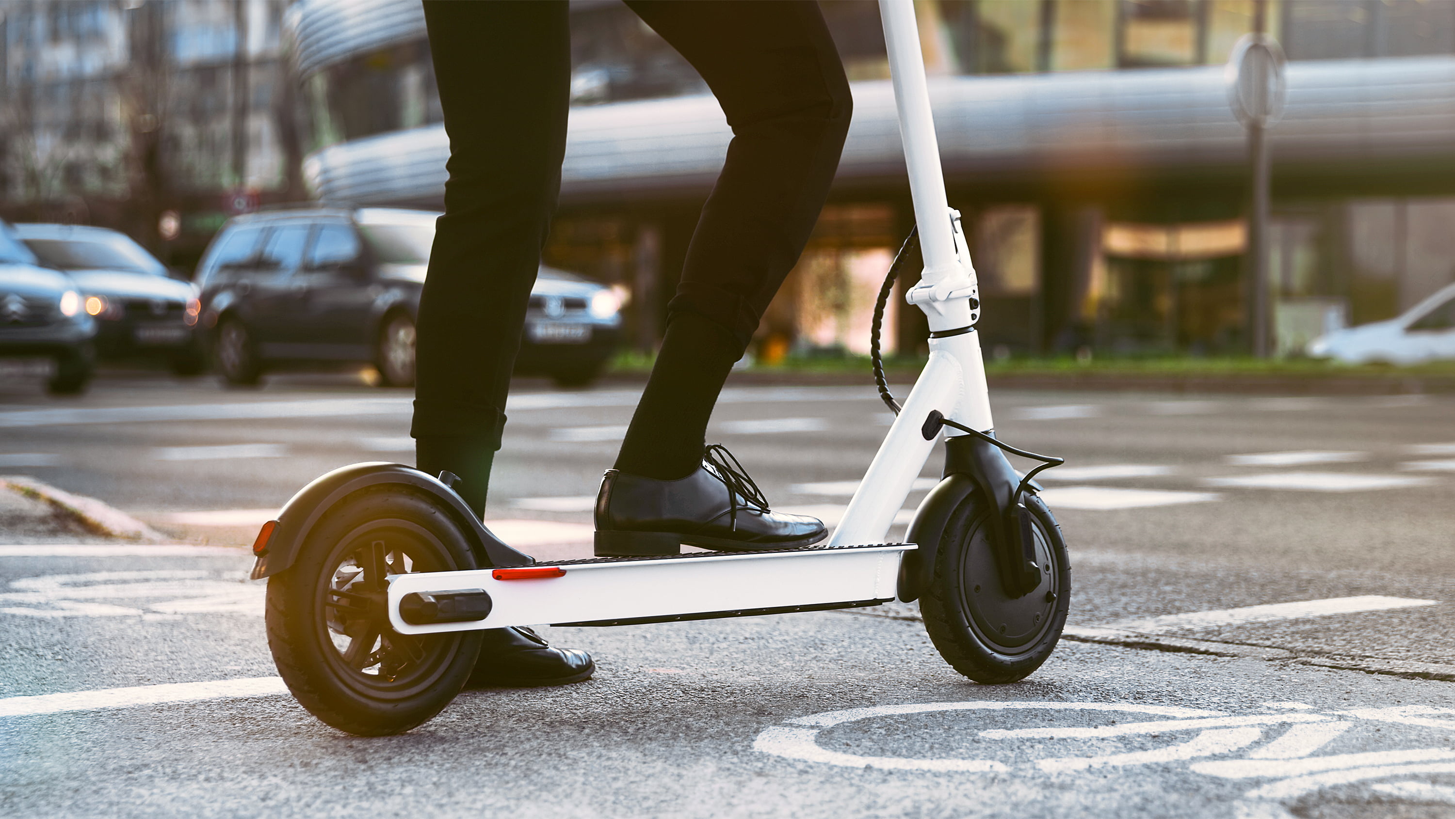 Individual stands on an e-scooter. (Photo: Getty Images)