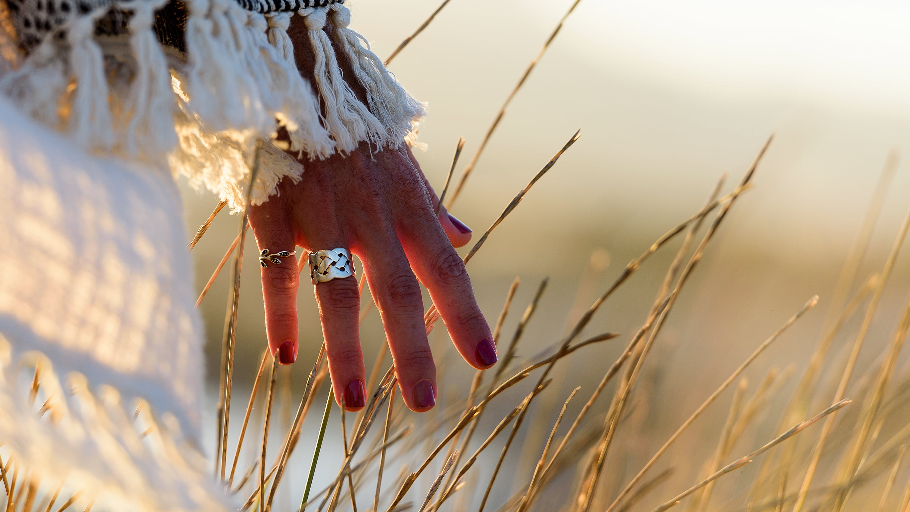 Close up of the hand of a female standing in a field of grain. (Photo: Getty Images)