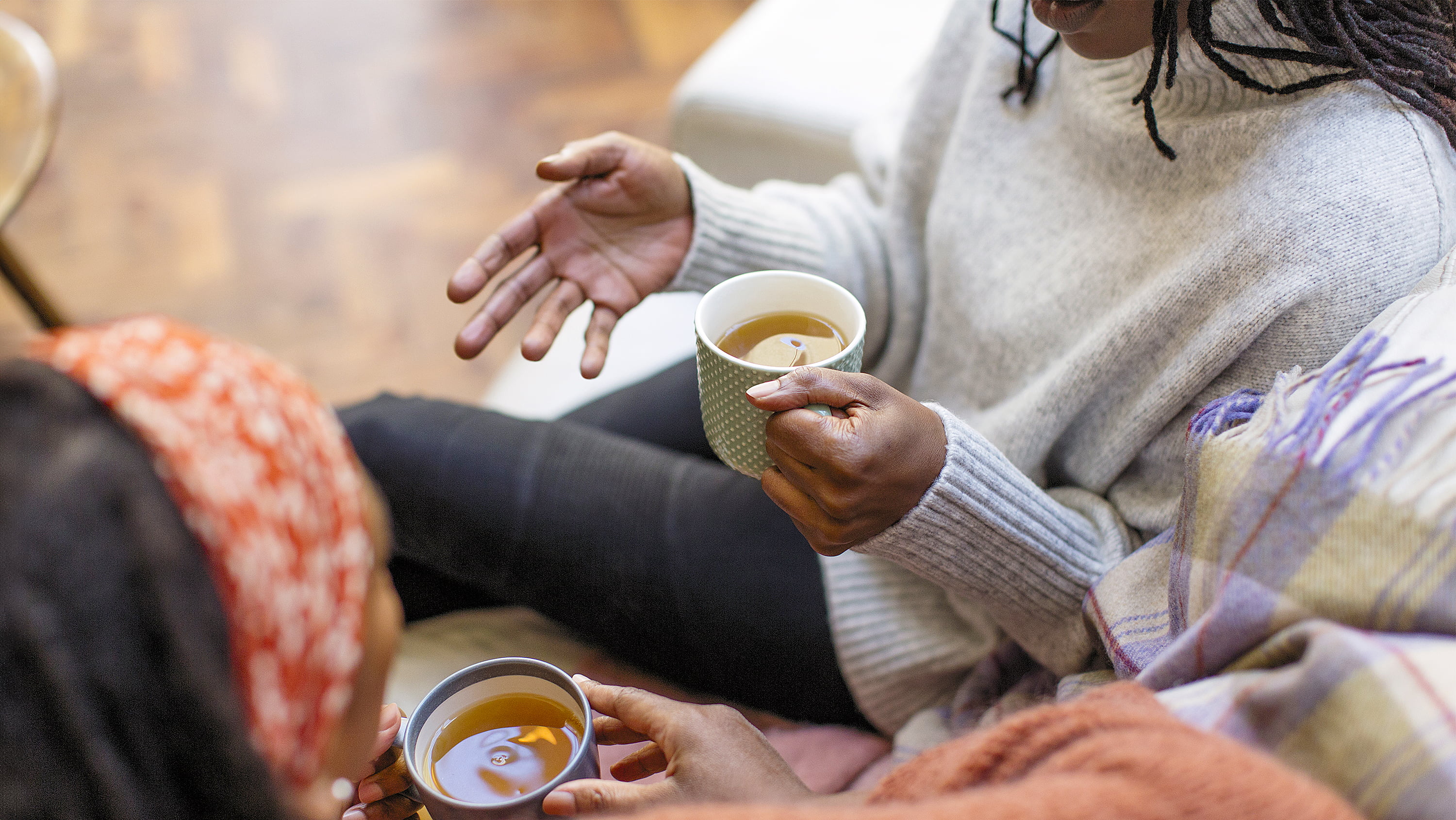 Two women have a conversation over tea. (Photo: Getty Images)